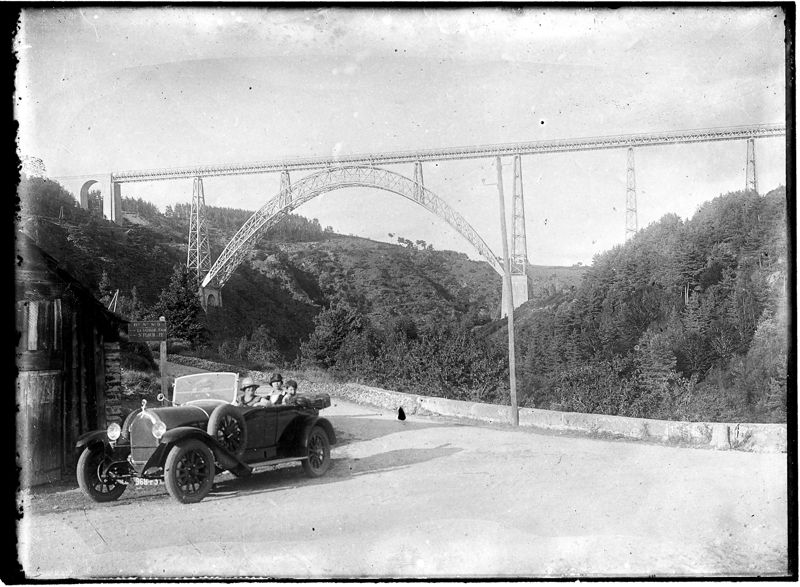 Touristes prenant la pose à bord de leur automobile, au pied du viaduc de Garabit
