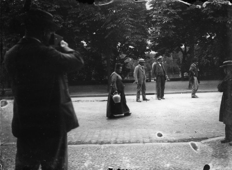 Photographe visant les passants avec son appareil photographique portable, autour du Square à Aurillac