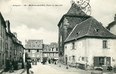Carte postale représentant la place du marché à Mur-de-Barrez. Un péage au profit du comte de Carladès était établi dans cette ville. [1916], ADC 10 NUM 700